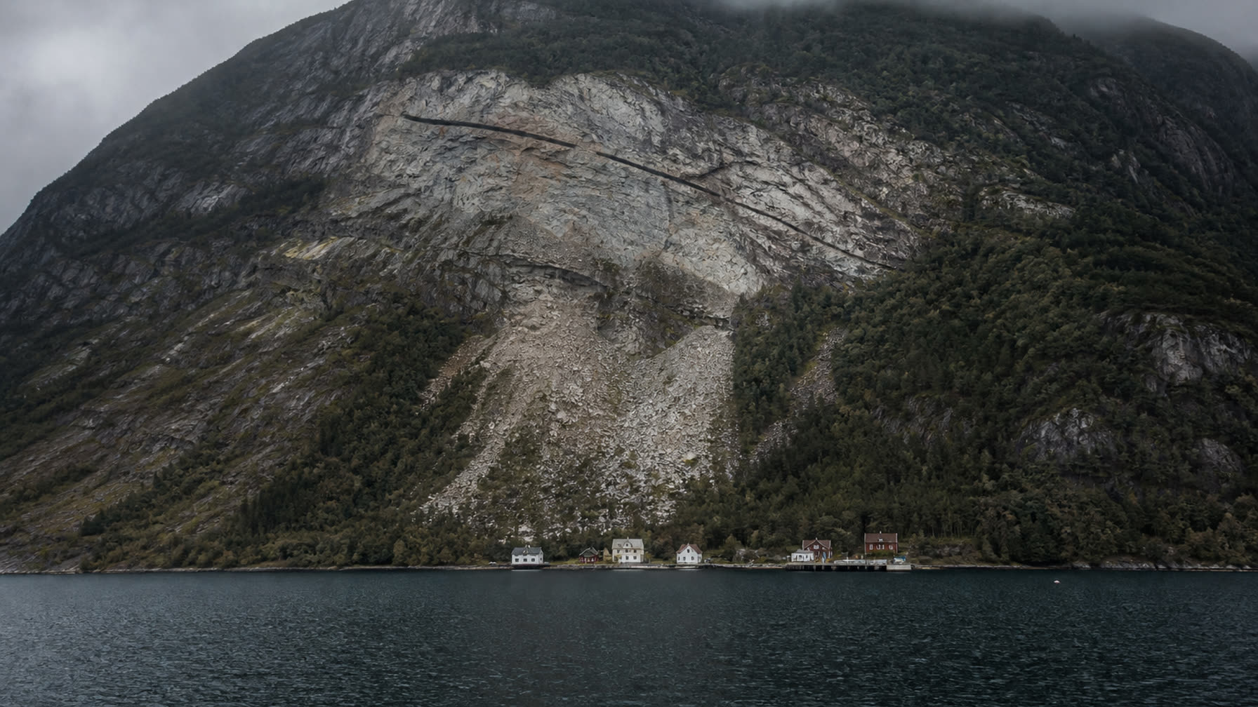 Vestnorsk fjord med bratt fjellside, skredarr og ur ned mot fjorden